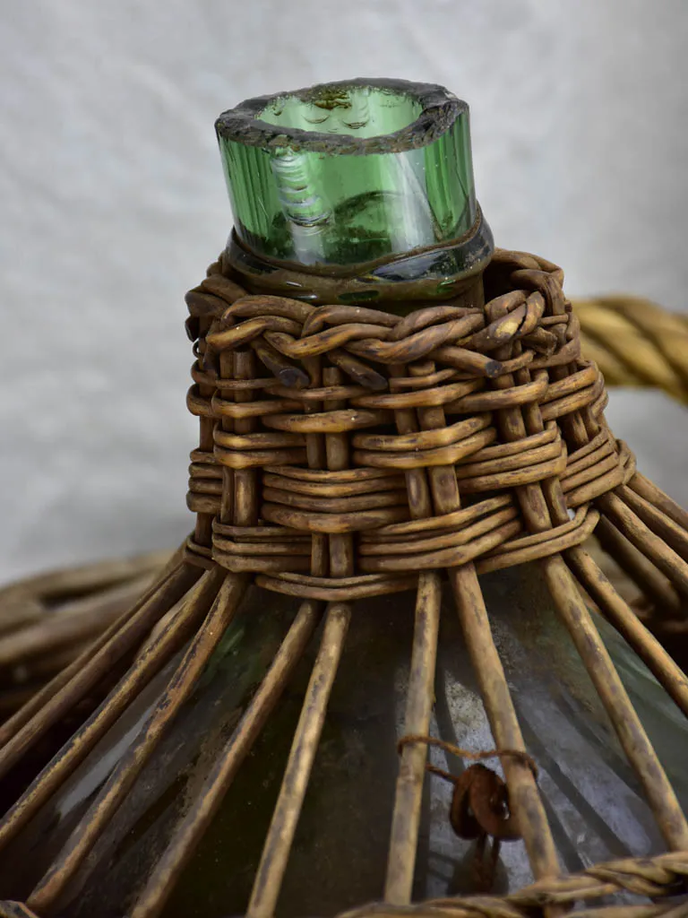 Very large antique French demijohn in a basket