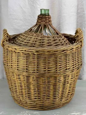 Very large antique French demijohn in a basket
